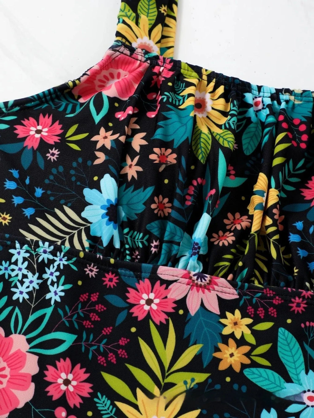 Women's pastoral floral print one-piece swimsuit on a hanger, showing the full design.
