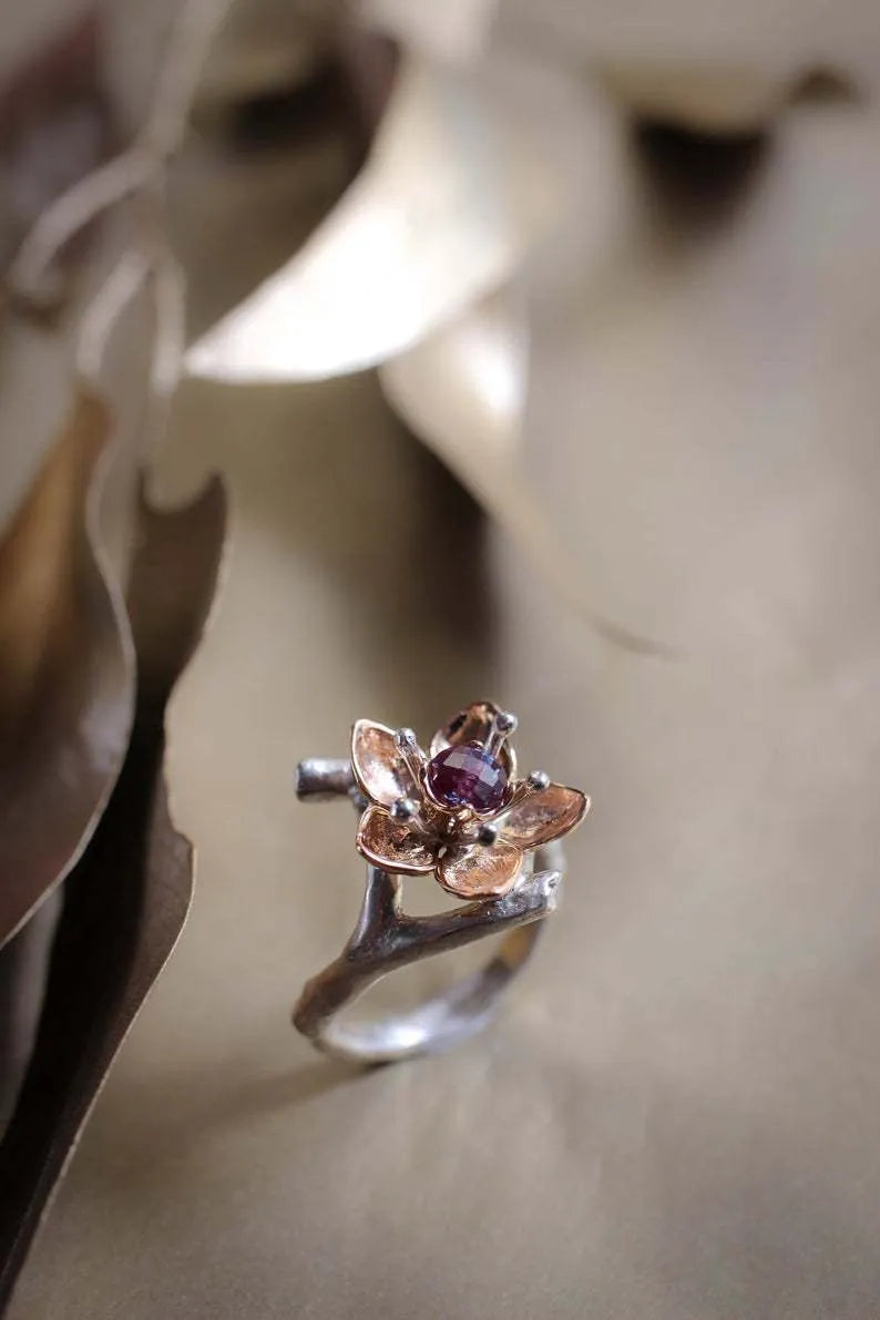 Silver and rose gold two-tone floral design alloy ring on a geometric band.