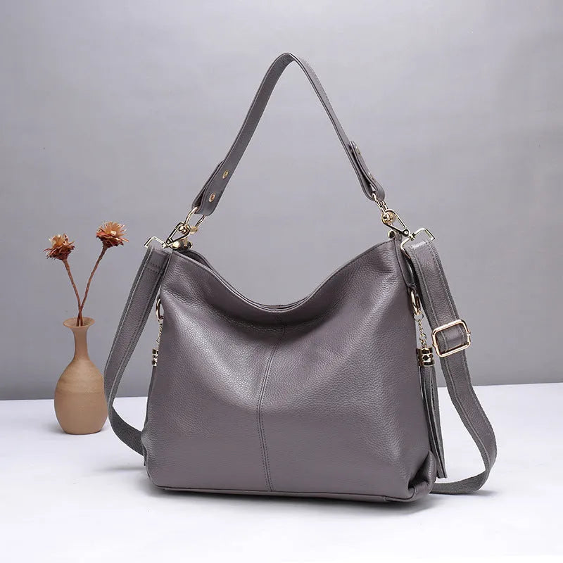 Square vertical genuine leather crossbody bag with multiple internal zipper compartments.