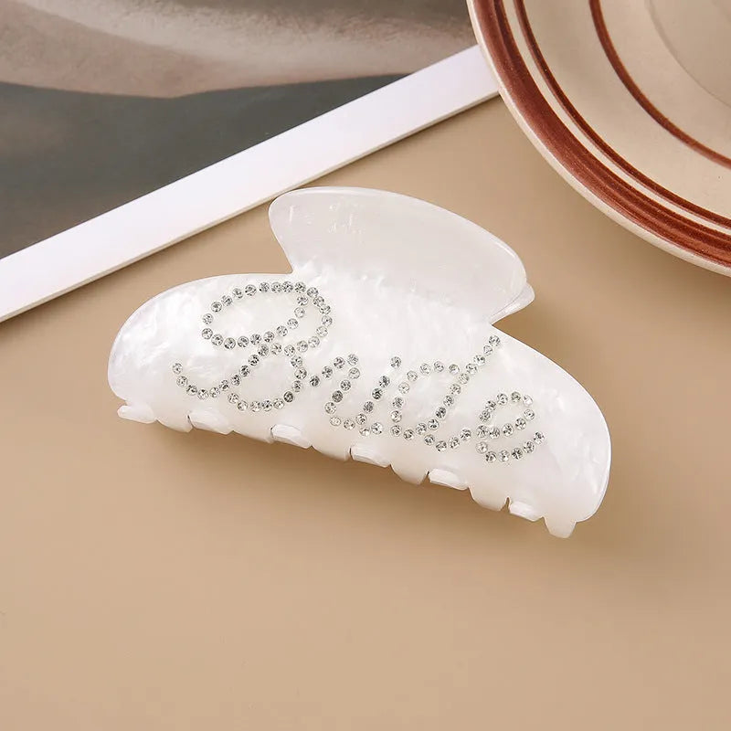 Pink and white acrylic barrette hair clip with diamond spot drilling and English letters.