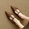 Brown women's round-toe flat shoes with a low heel and metal detail on a leather upper.