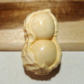Carved solid bamboo peanut ornament in a modern simplicity style on a plain background.
