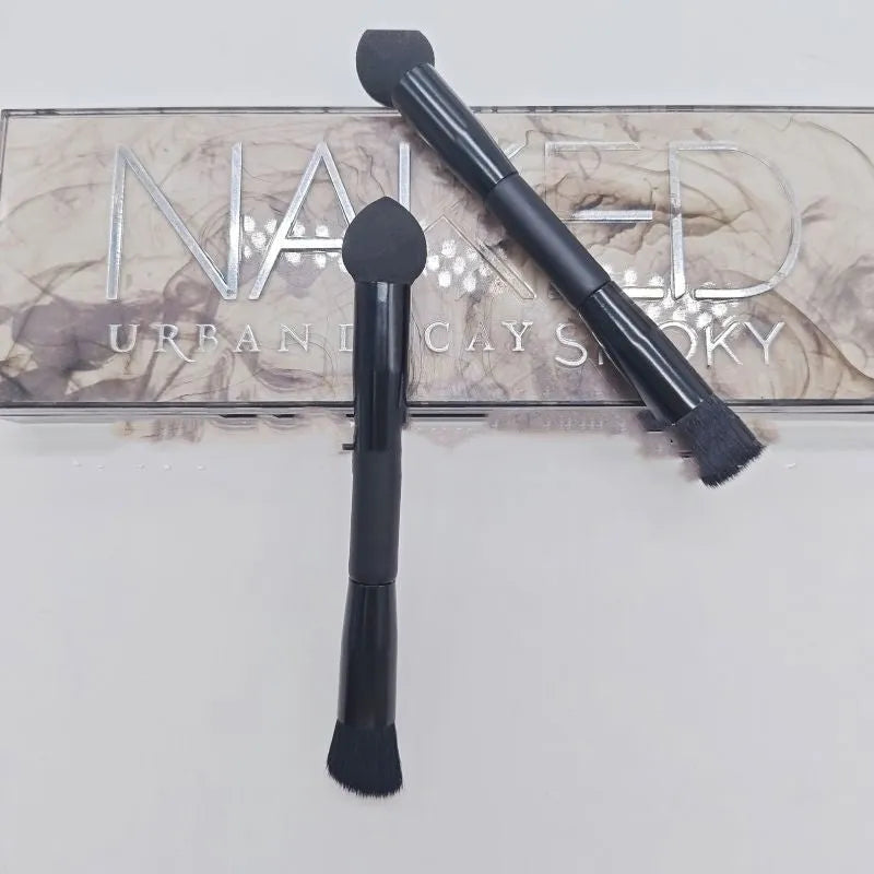 Black dual-ended concealer brush with a wooden handle and a pointed sponge applicator tip for under-eye makeup.