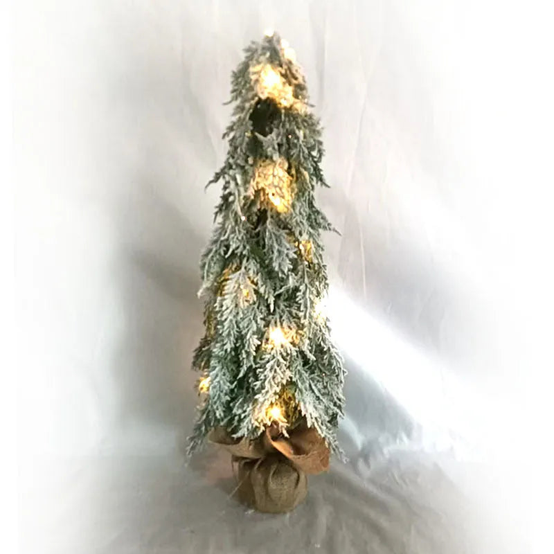 Small 24-inch white artificial Christmas tree with LED lights and snow-covered branches on a desktop.
