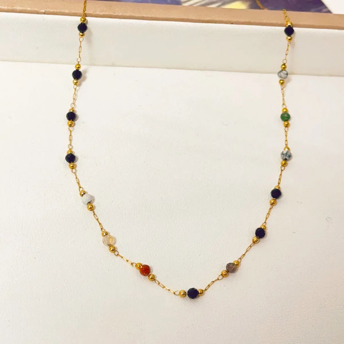 Gold titanium steel necklace with natural stone pendant on female model