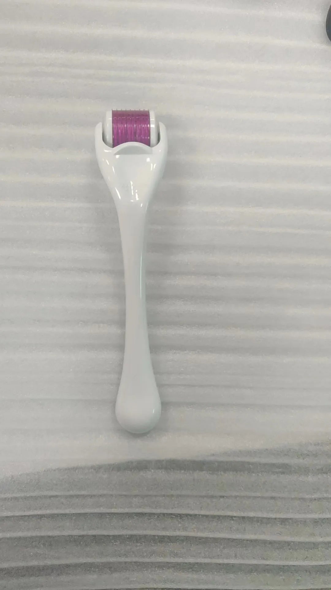 540 needle micro roller dermaroller with black handle and purple wheel, showing needle depth settings.
