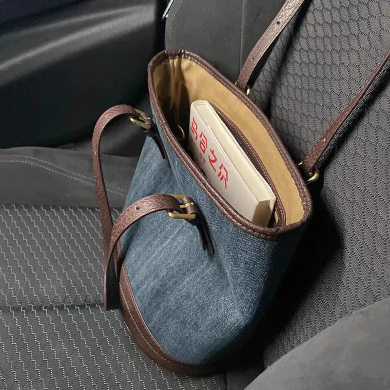 Large denim patchwork bucket handbag showing adjustable strap and retro styling