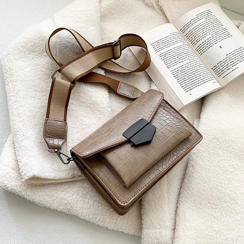 Vintage PU crossbody bag in black, shown with adjustable strap and open to reveal polyester lining.