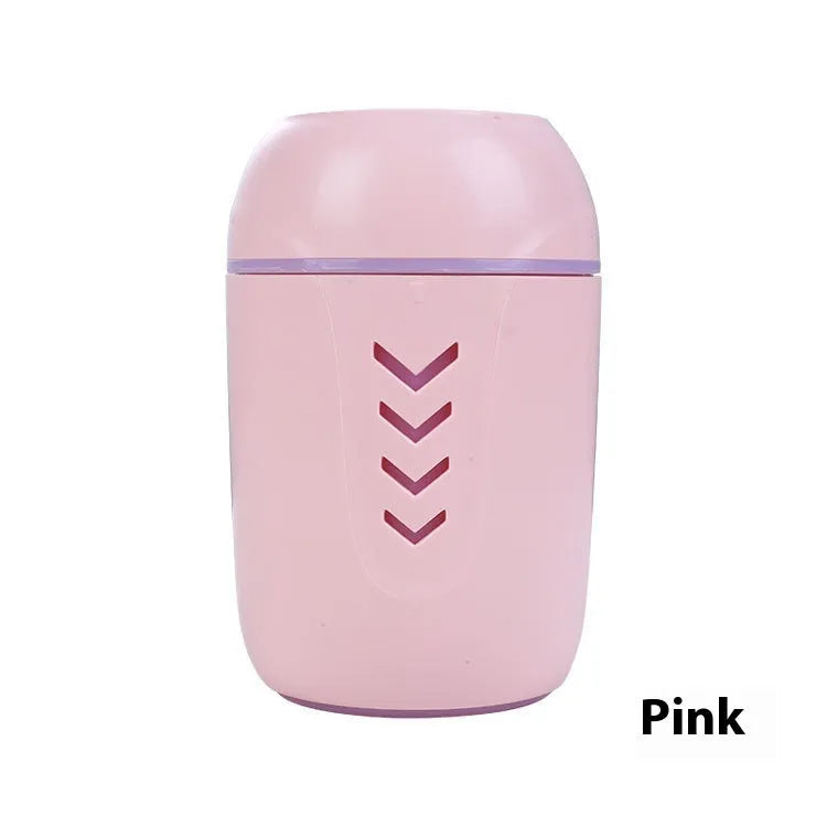 Round white portable air purifier with USB cable on a wooden desk.