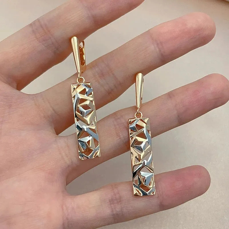 Close-up of women's rectangular hollow two-tone alloy stud earrings on a white background.