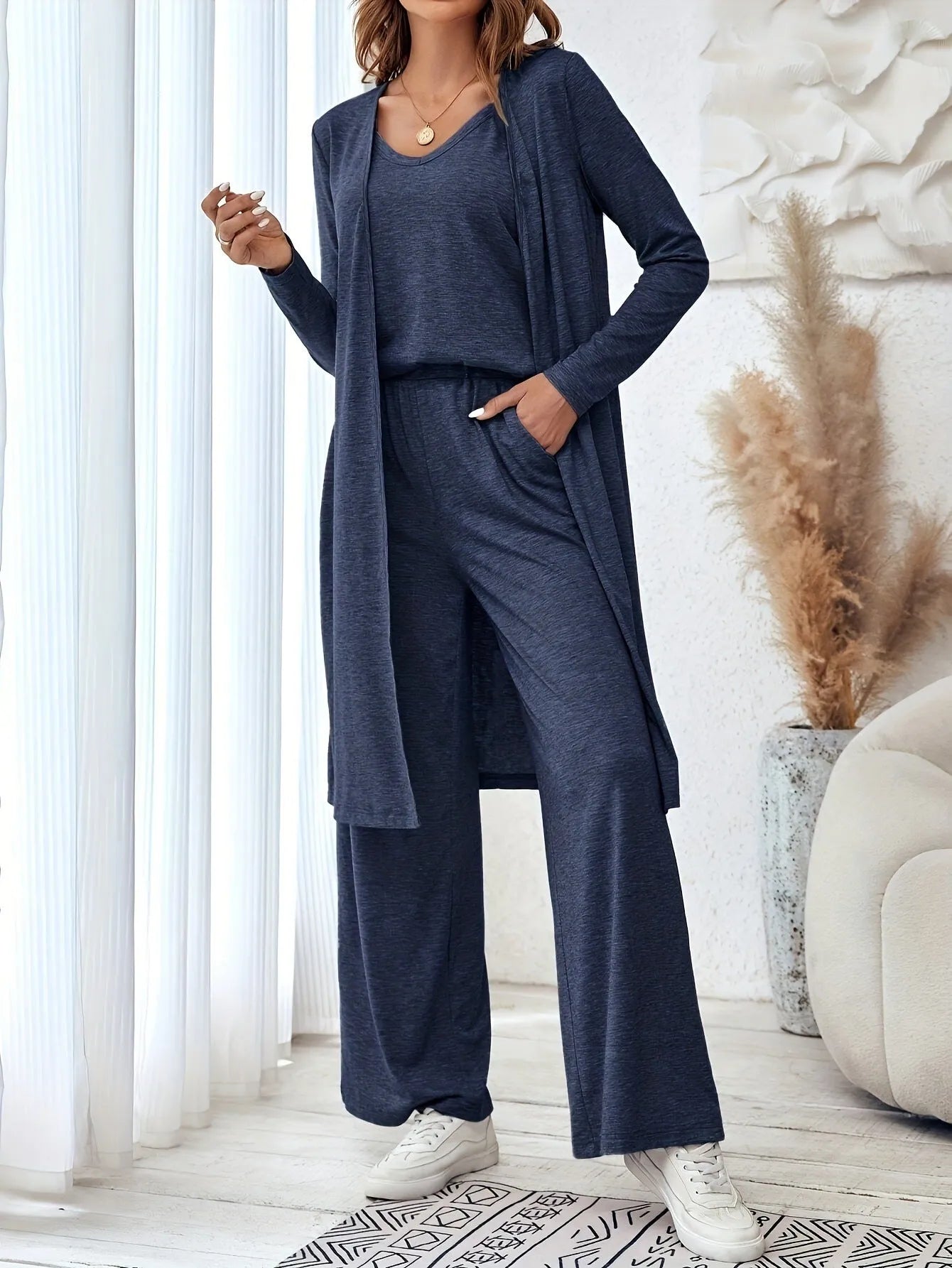 Blue women's three-piece casual suit set featuring trousers, a long-sleeve top, and suspenders on a hanger.