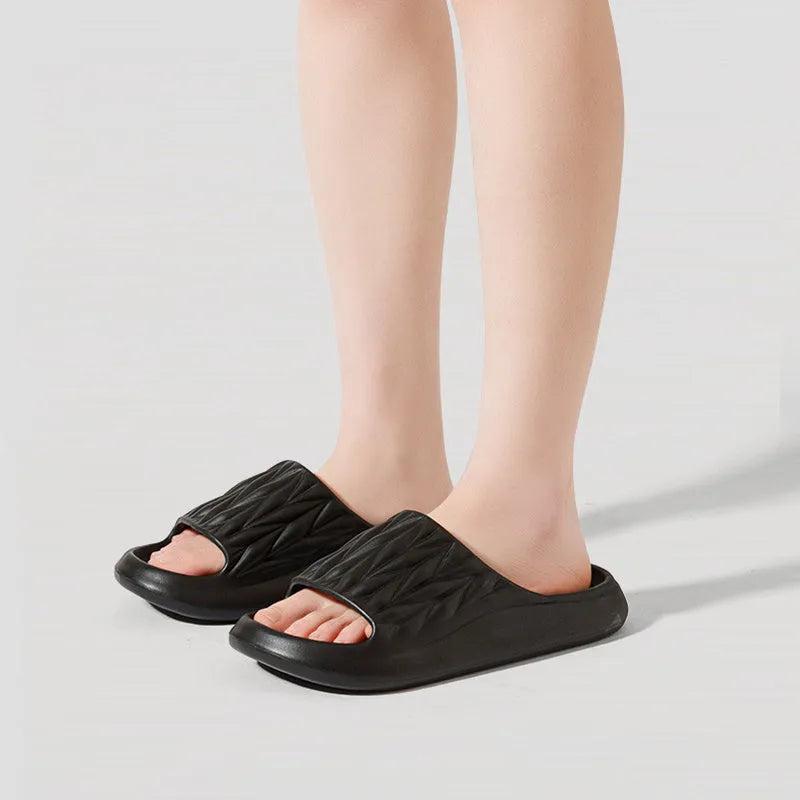 Pair of leaf-textured EVA indoor slippers on a solid background, showing non-slip sole.