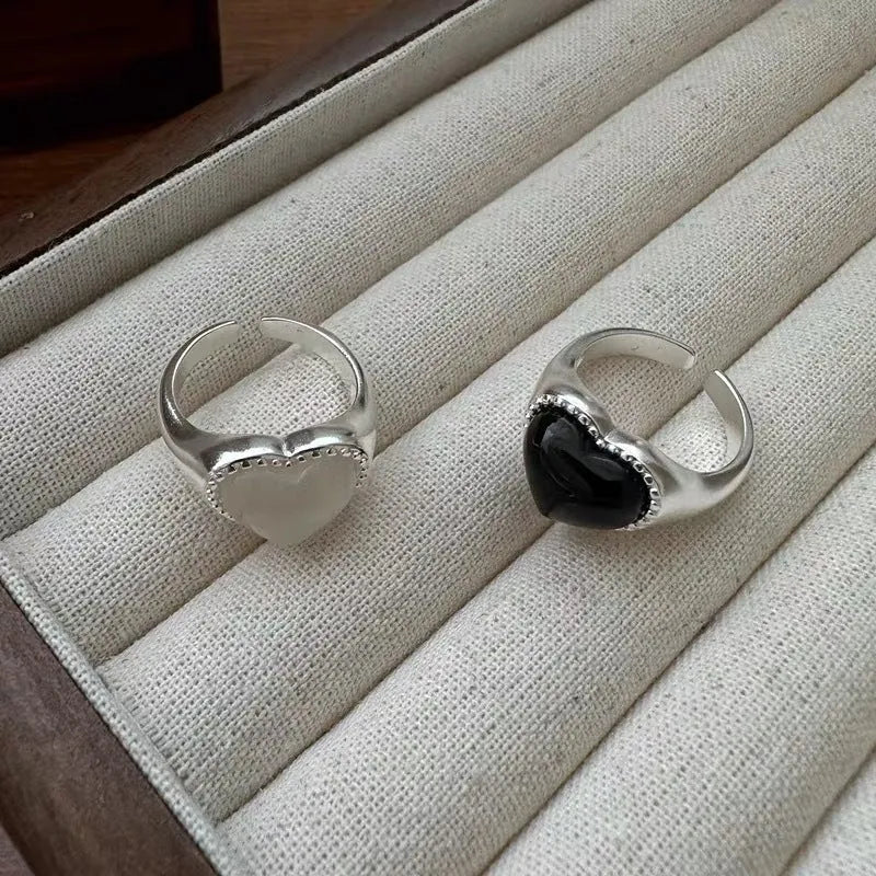 S925 sterling silver adjustable ring with a black agate heart centrepiece on a finger.