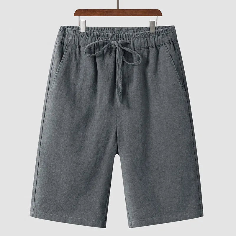 Man wearing beige linen cropped shorts with a loose fit and elasticated waist