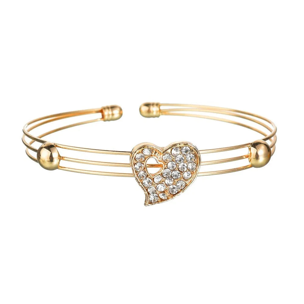 Gold-colour women's jewellery set with earrings, adjustable necklace and bracelet featuring heart, water drop and bell charms.