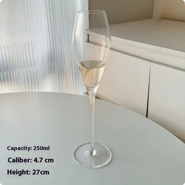 A single clear French goblet champagne glass on a table.