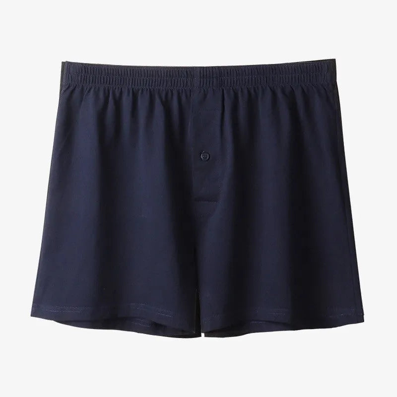 Men's solid colour loose-fit cotton boxer shorts on a white background, showing high waist and leg openings.