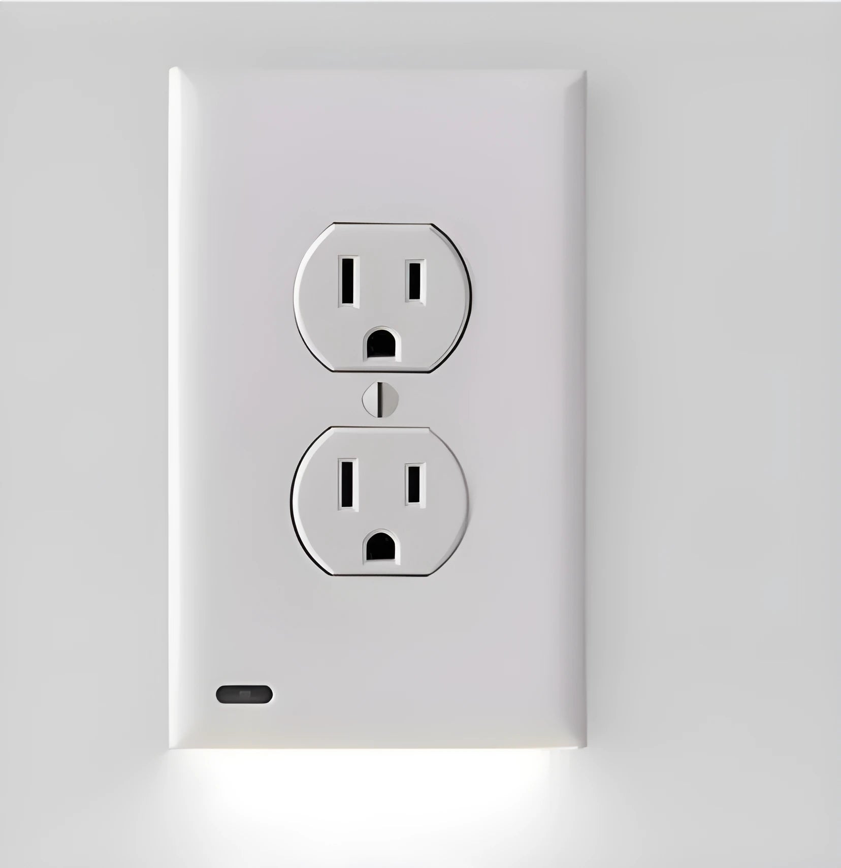 White plug-in LED socket cover night light with automatic sensor installed on a wall outlet.