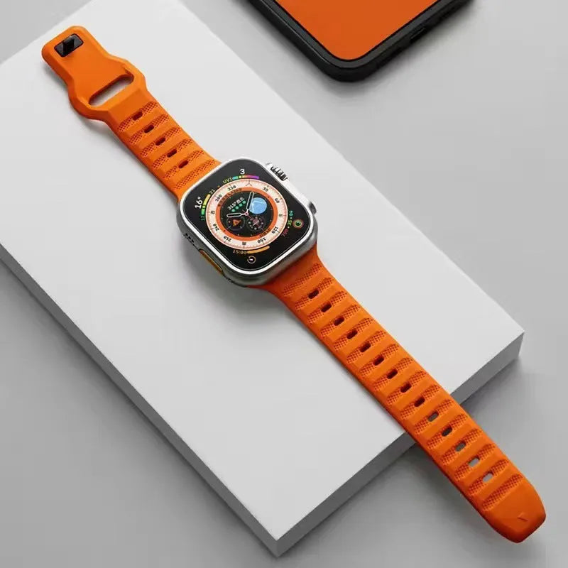 Fluoro rubber Apple Watch band with T-buckle in multiple colours on a grey background