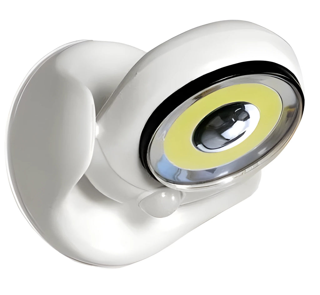 White Atomic Angel induction table lamp with compact ABS plastic body on a table.