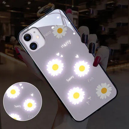 White luminous iPhone case with purple daisy design and voice-activated colour light on a table.