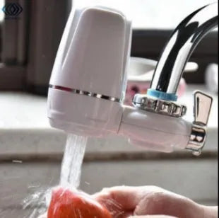White plastic faucet-mounted water filter with ceramic cartridge and tap adapters