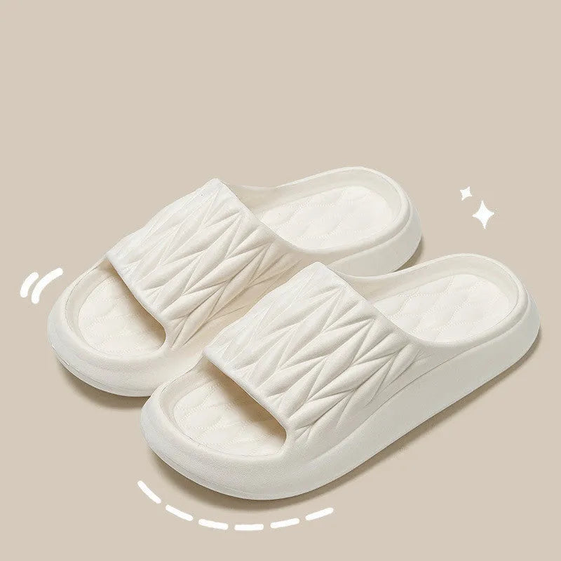 Pair of leaf-textured EVA indoor slippers on a solid background, showing non-slip sole.