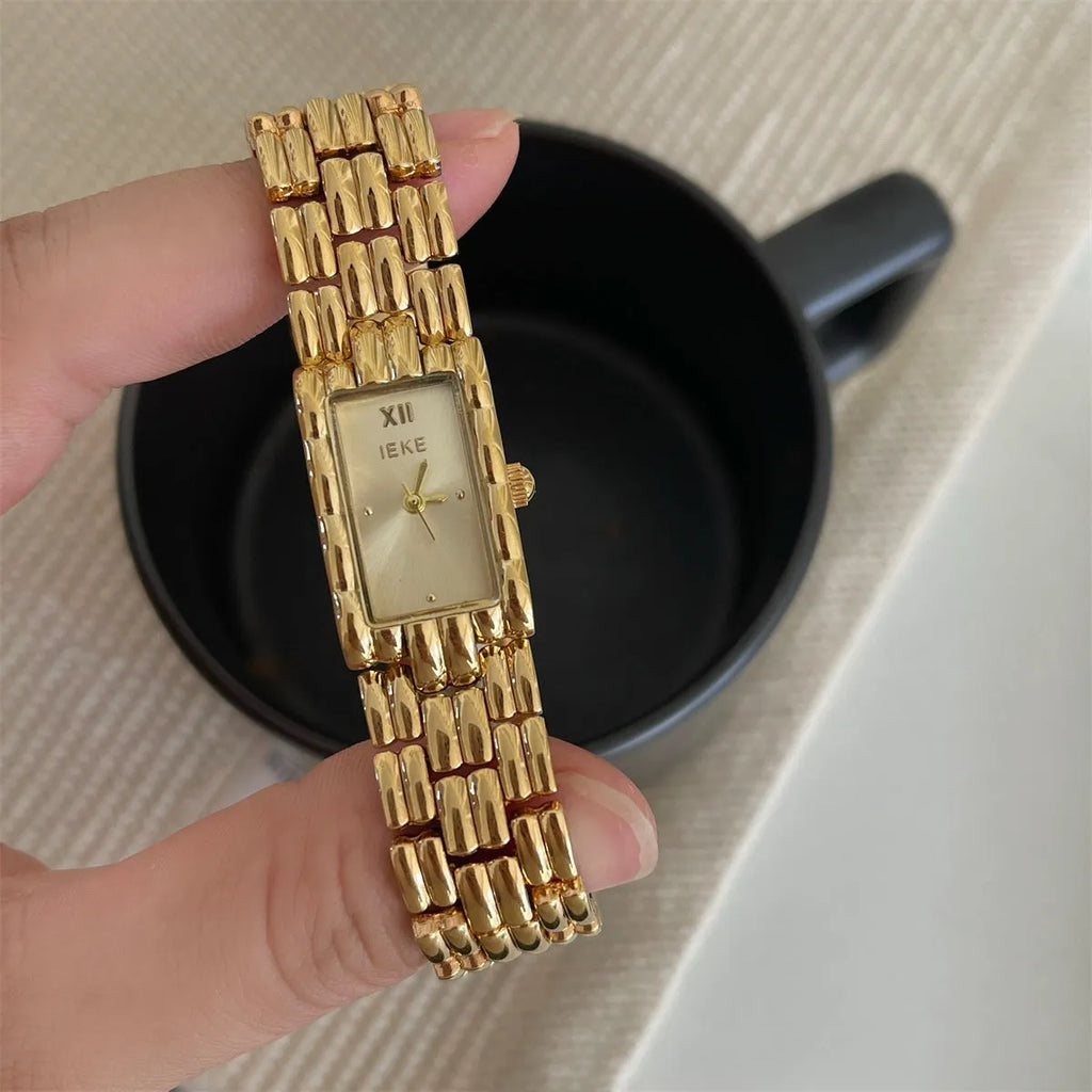 Women's silver and gold bracelet-style vintage watch with 15mm dial on wrist
