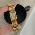 Women's silver and gold bracelet-style vintage watch with 15mm dial on wrist