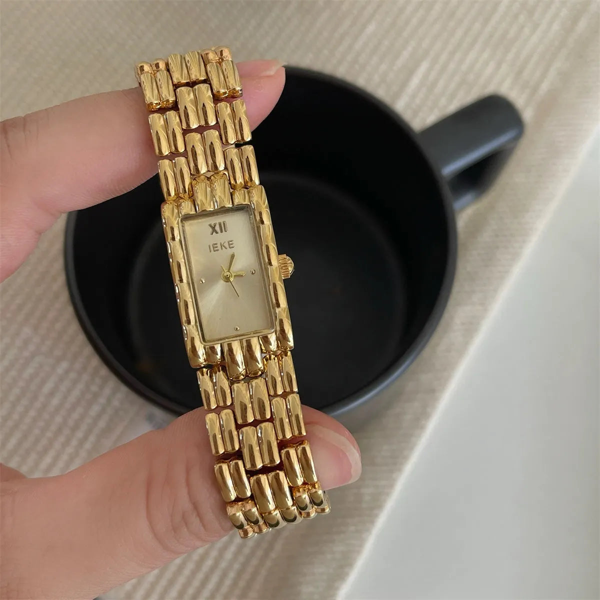 Women's silver and gold bracelet-style vintage watch with 15mm dial on wrist
