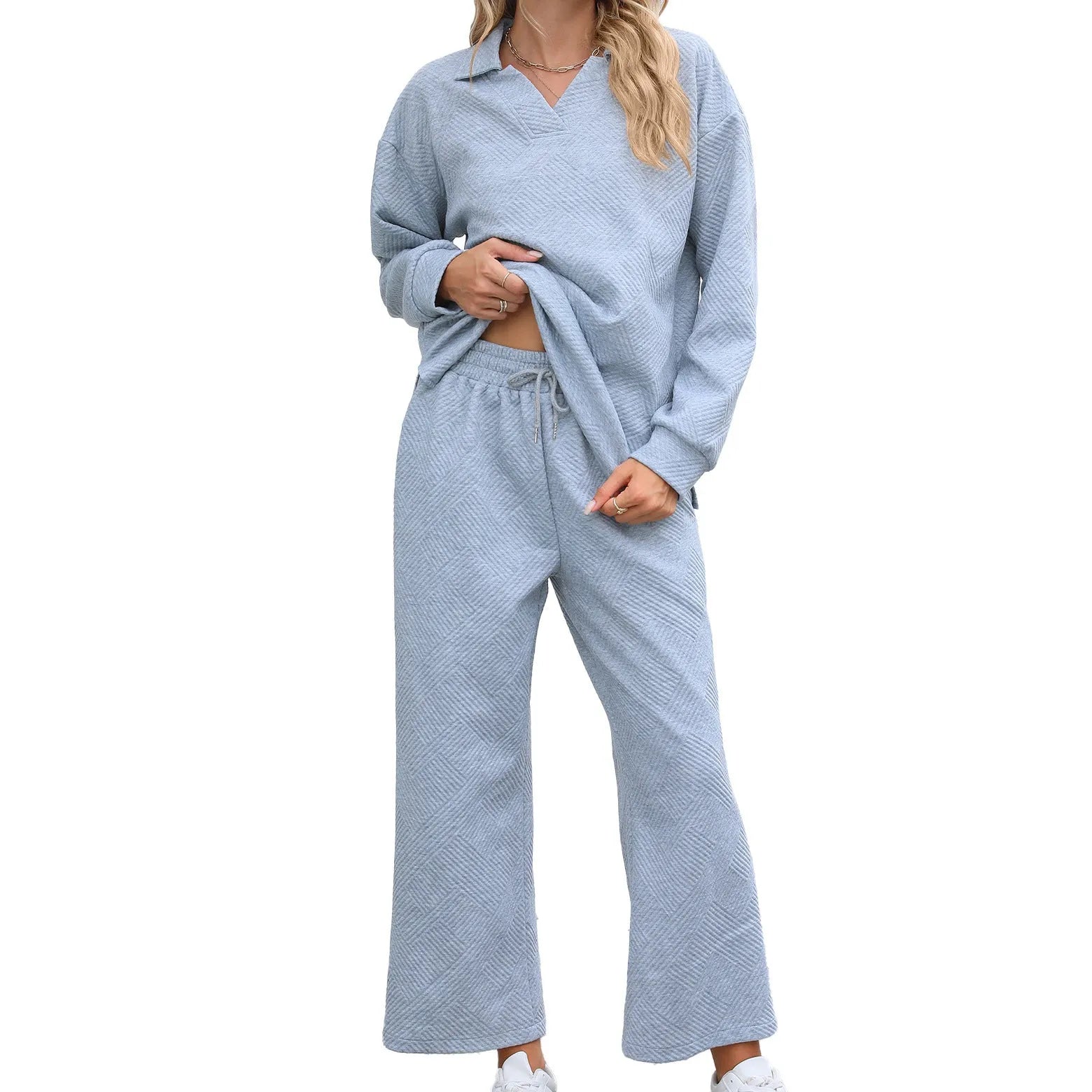 Women's black geometric pattern knitted suit set with long sleeve top and elastic waist cropped trousers.