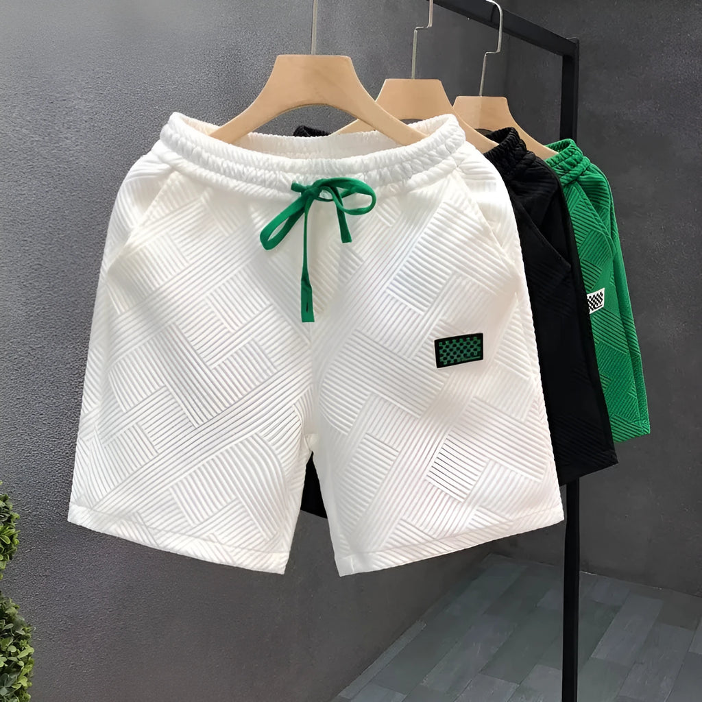 Men's solid colour polyester sports shorts with micro elasticity in white, black, or green.