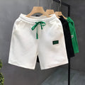 Men's solid colour polyester sports shorts with micro elasticity in white, black, or green.