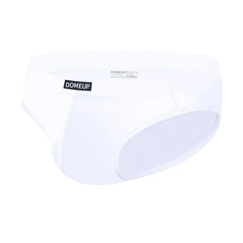 Men's solid colour seamless low-waist briefs in white, black, and pink laid flat.