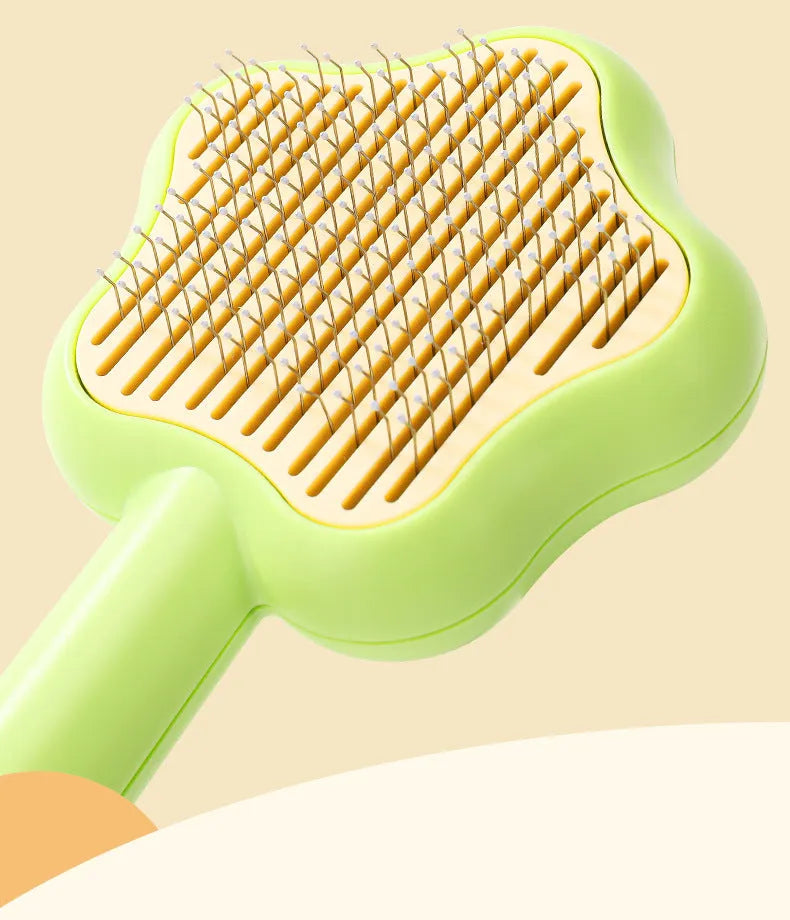 Green stainless steel self-cleaning cat comb with needle bristles on a white background.
