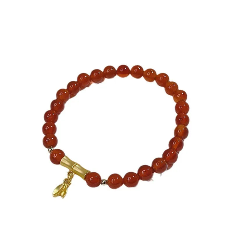 A red agate bracelet for women with Chinese style dragon and lucky bag motifs.