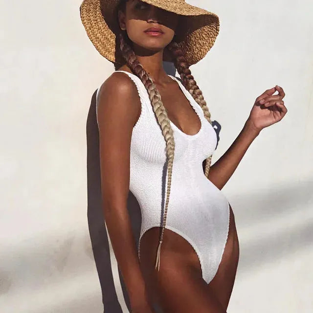 Solid colour seersucker bubble cloth one-piece swimsuit for women in a backless, sleeveless design.