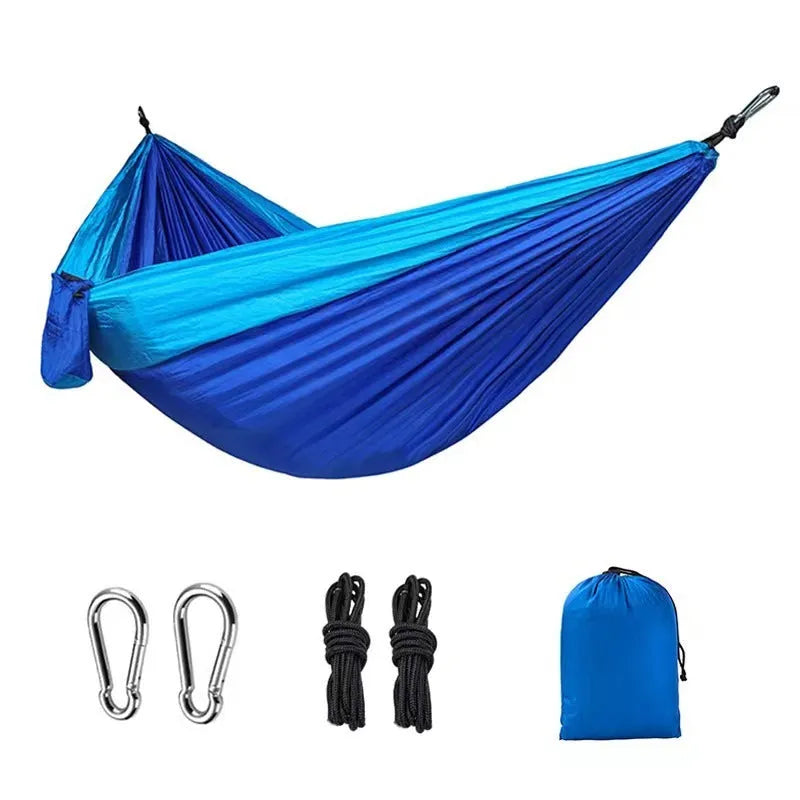 Blue nylon parachute cloth outdoor hammock with reinforced stitching hung between trees