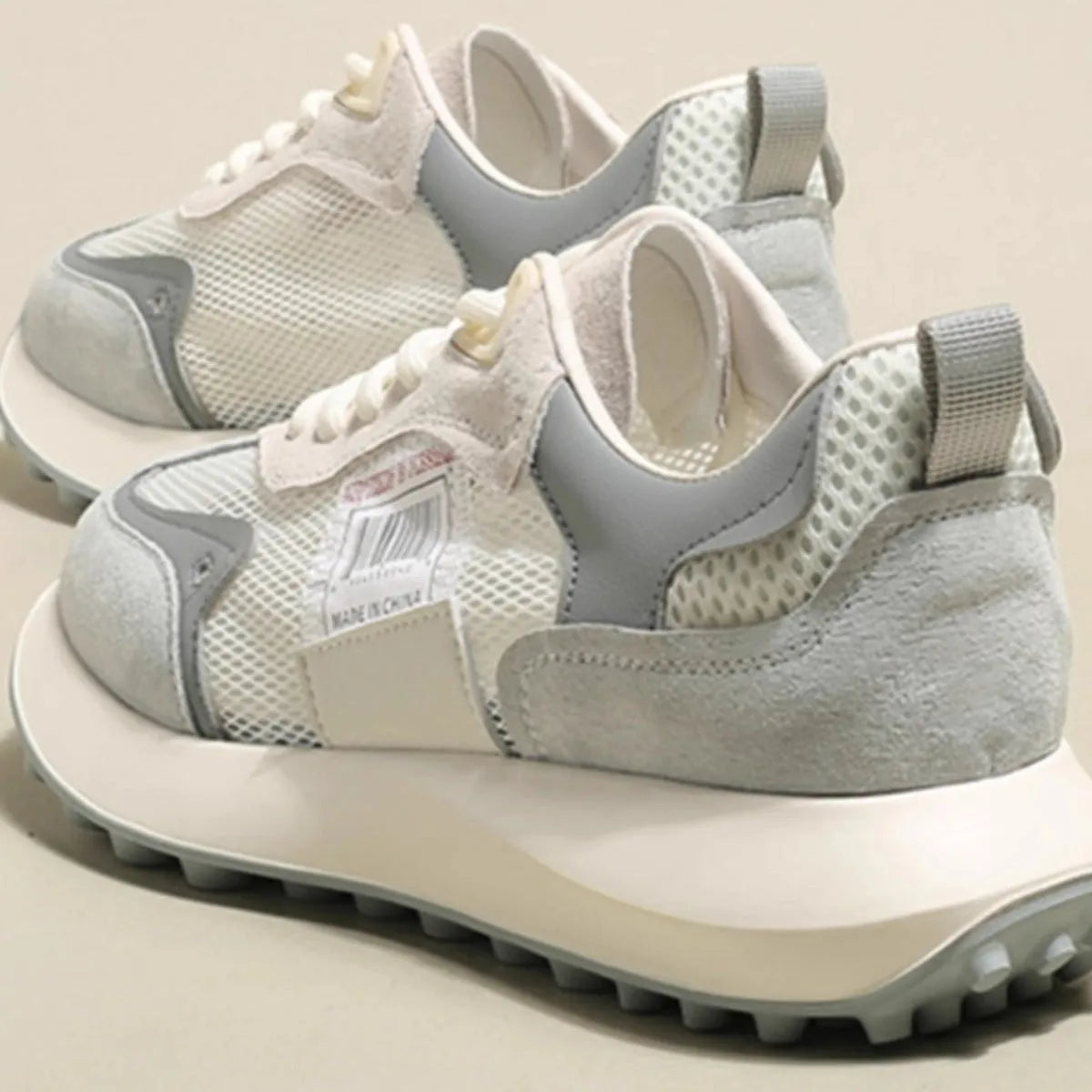 Women's grey and pink retro sneakers with mesh lining, rubber sole, and round toe design