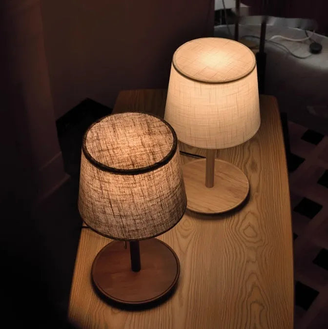 Walnut coloured solid wood desk lamp with a white fabric lampshade and a cable switch.