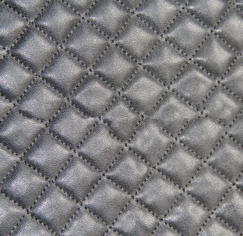 Black quilted automotive seat cover with PU and polyester construction shown on car seat