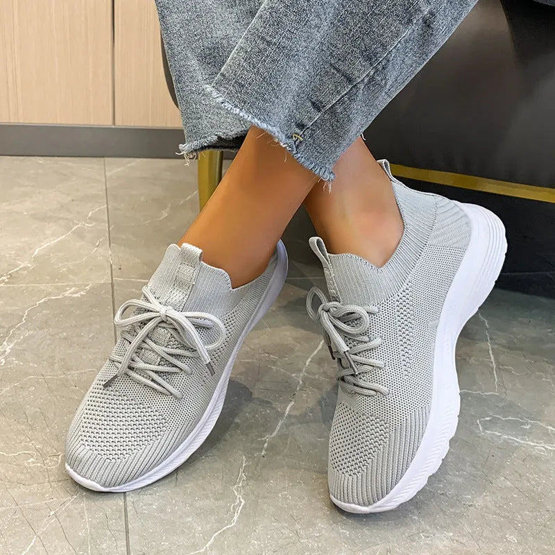 Women's cream running shoes with breathable mesh upper and flat rubber sole