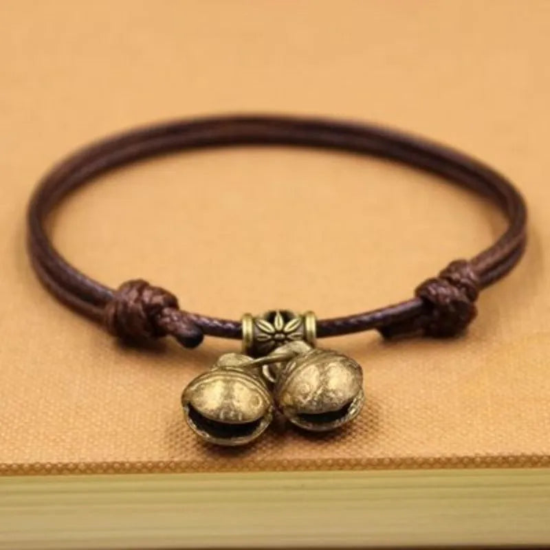 Small dog wearing adjustable nylon rope collar with brass bell in black, red or coffee colour
