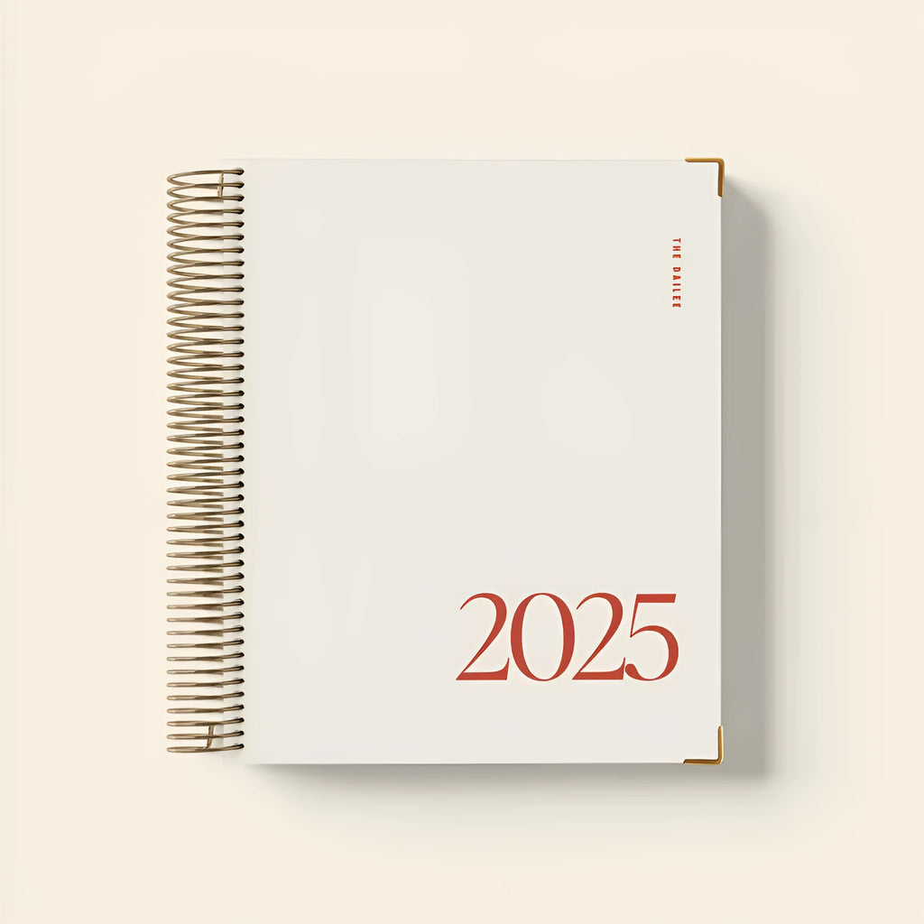 Cherry red spiral bound daily planner notebook with A5 paper pages open on desk