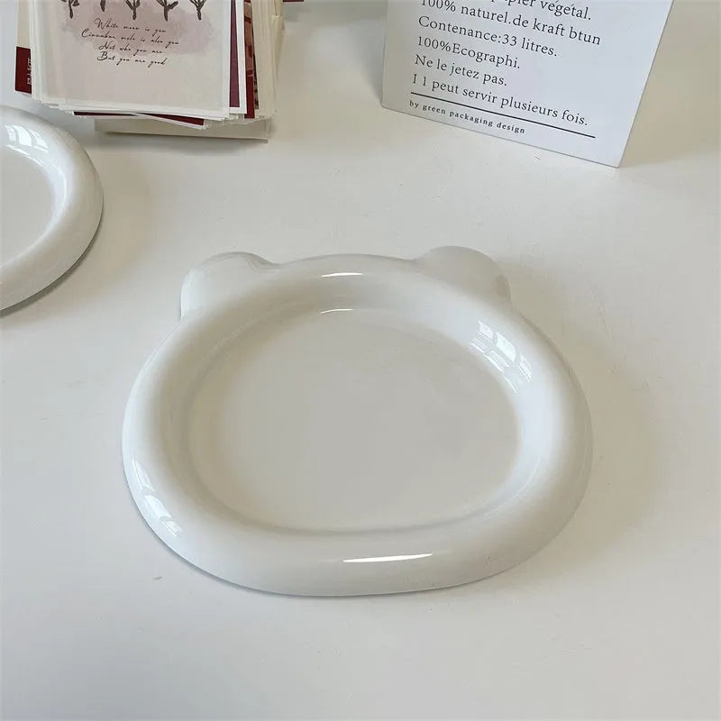 White porcelain plate with chubby toot or bear doodle pattern, shown in 15cm and 20cm round sizes.