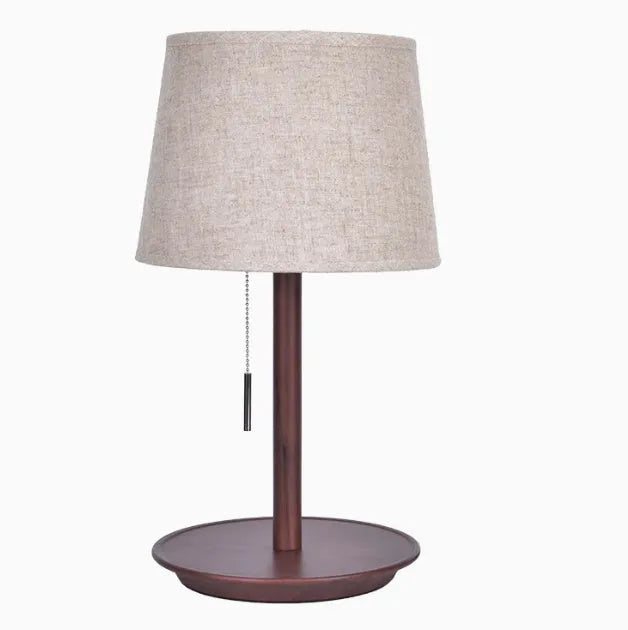 Walnut coloured solid wood desk lamp with a white fabric lampshade and a cable switch.