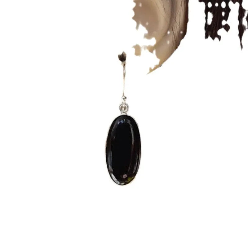 Pair of women's earrings with oval black agate pendant on silver electroplated alloy geometric setting.