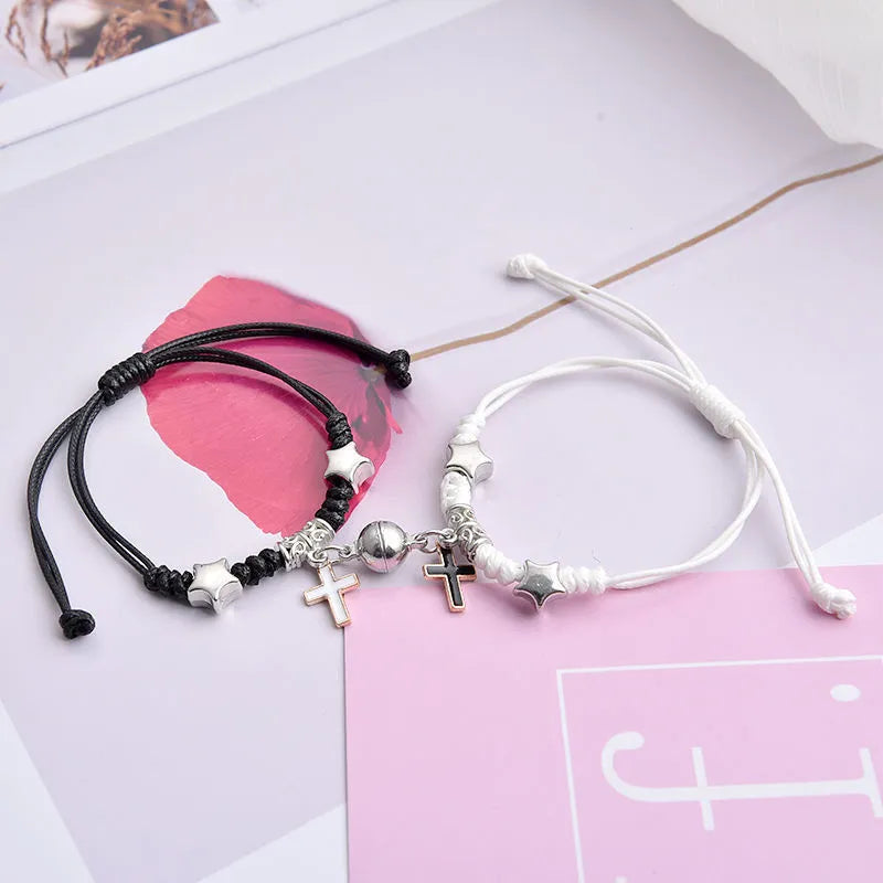 Pair of magnet couple bracelets with suction clasp on wrist, showing alloy designs like crown and love lock.