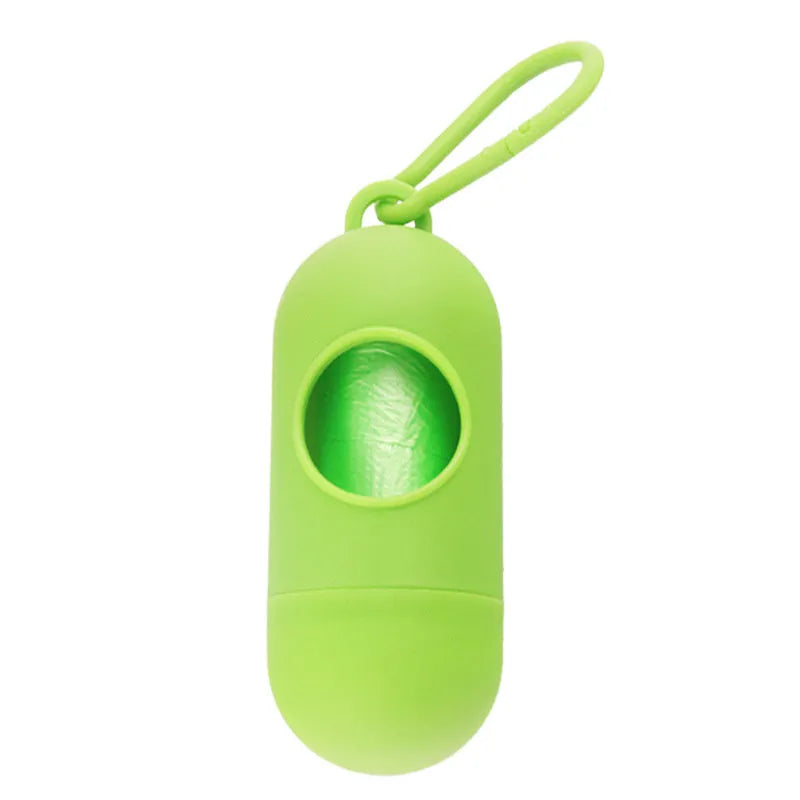 A small black plastic dog poop bag holder with a hook and Velcro strap, shown next to a roll of bags.