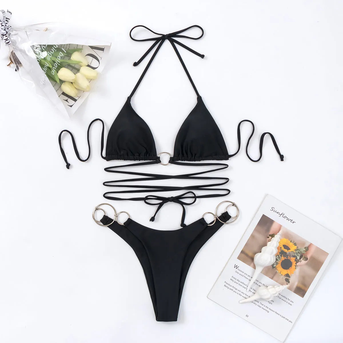 Solid black women's bikini set with long straps and metal rings, showing backless design.
